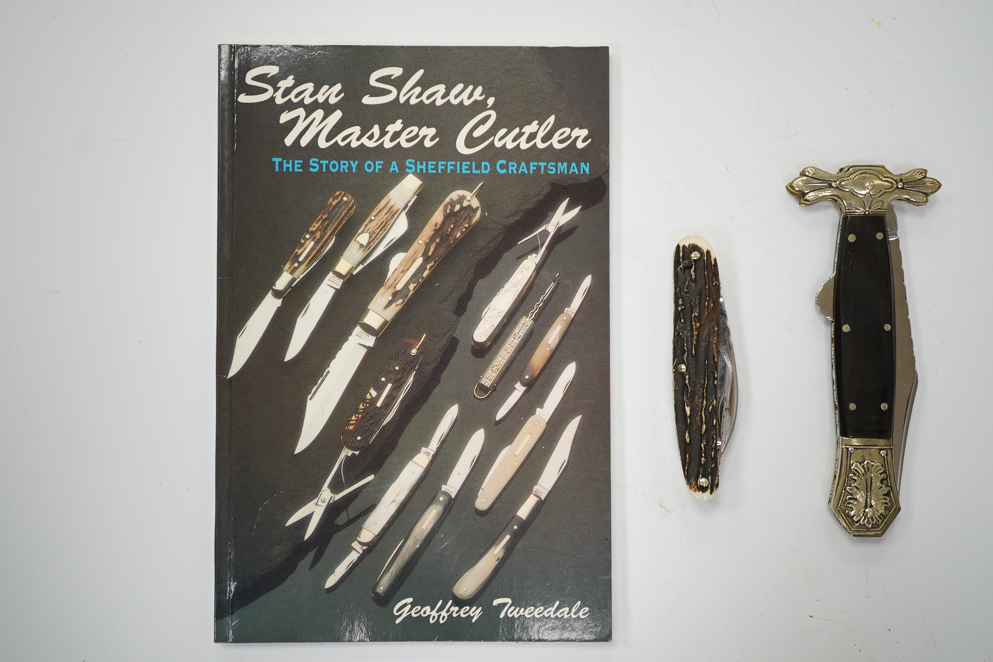 Stan Shaw, two knives; a pen knife with horn handle and a folding knife and a related book, signed. Condition - good